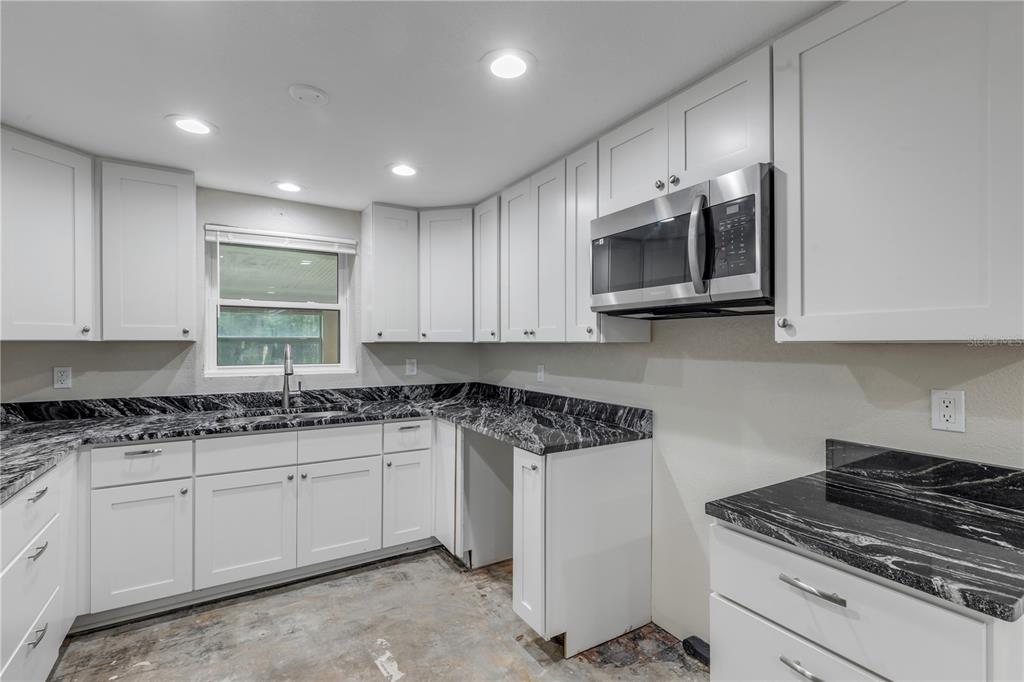 103 Flagler Avenue Edgewater, FL 32132 - Photo 25 of 53 a kitchen with stainless steel appliances granite countertop a sink stove and microwave