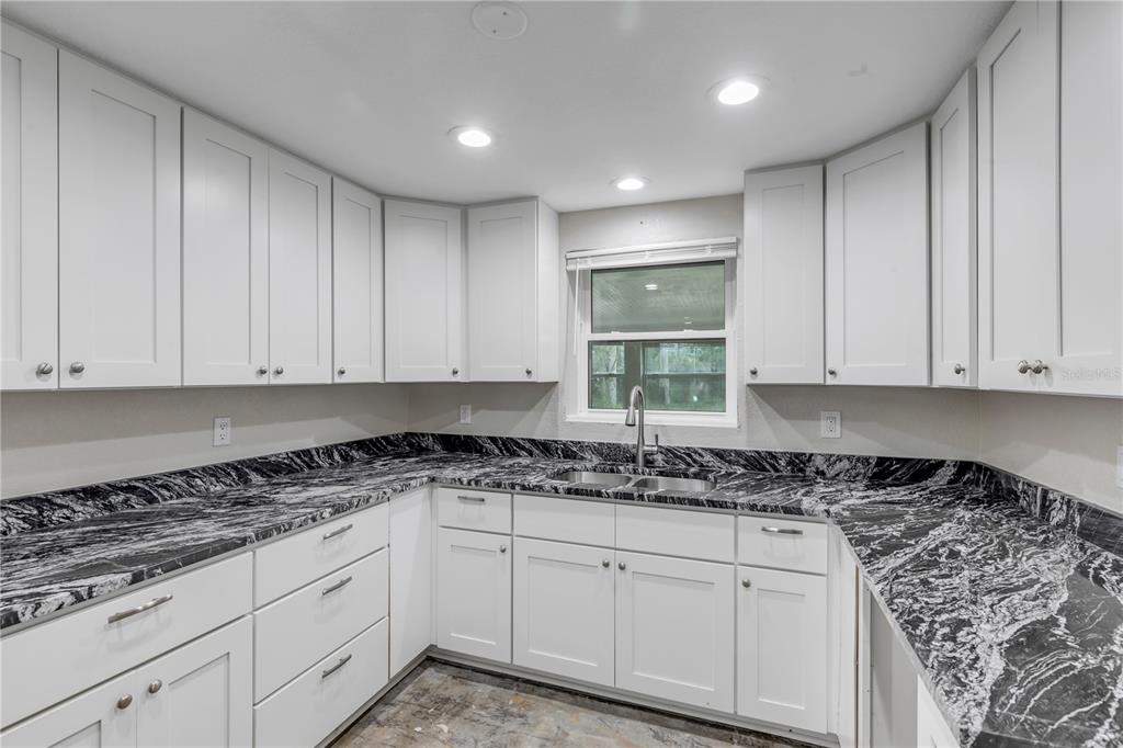 103 Flagler Avenue Edgewater, FL 32132 - Photo 26 of 53 a kitchen with granite countertop a sink and cabinets