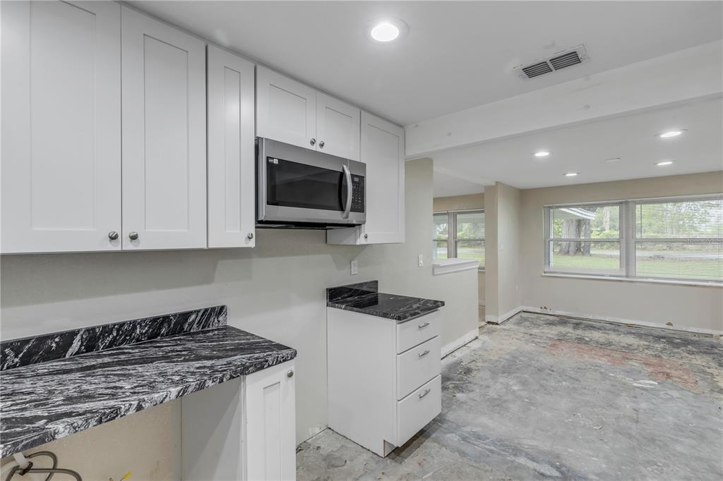 103 Flagler Avenue Edgewater, FL 32132 - Photo 27 of 53 a kitchen with stainless steel appliances granite countertop a stove a sink and a microwave