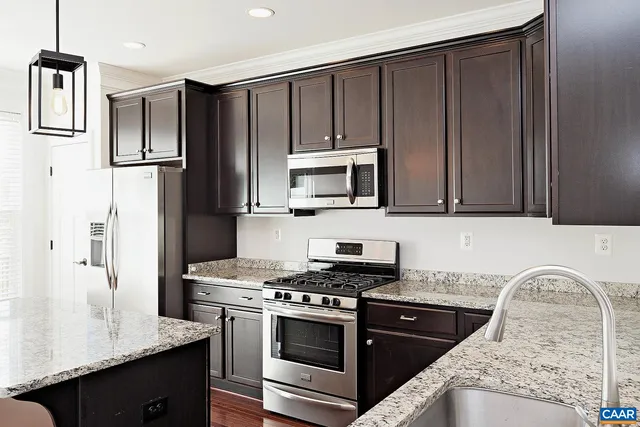 a kitchen with granite countertop wooden cabinets and stainless steel appliances