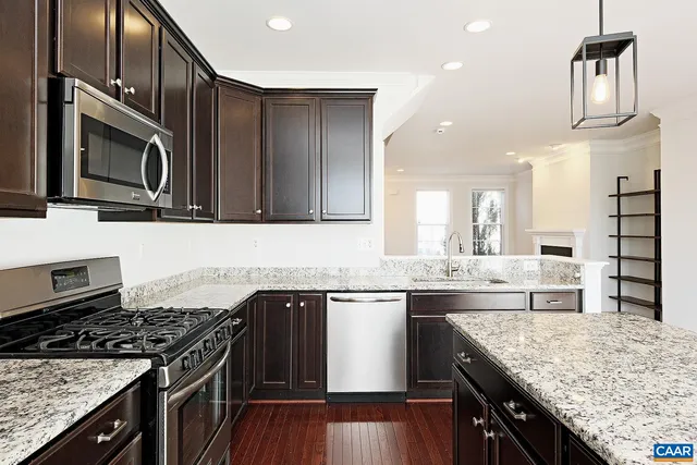 a kitchen with stainless steel appliances granite countertop a sink stove microwave and cabinets