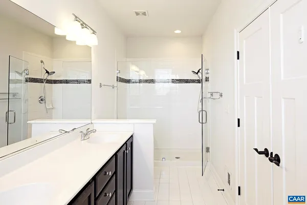 a bathroom with a double vanity sink a mirror and shower