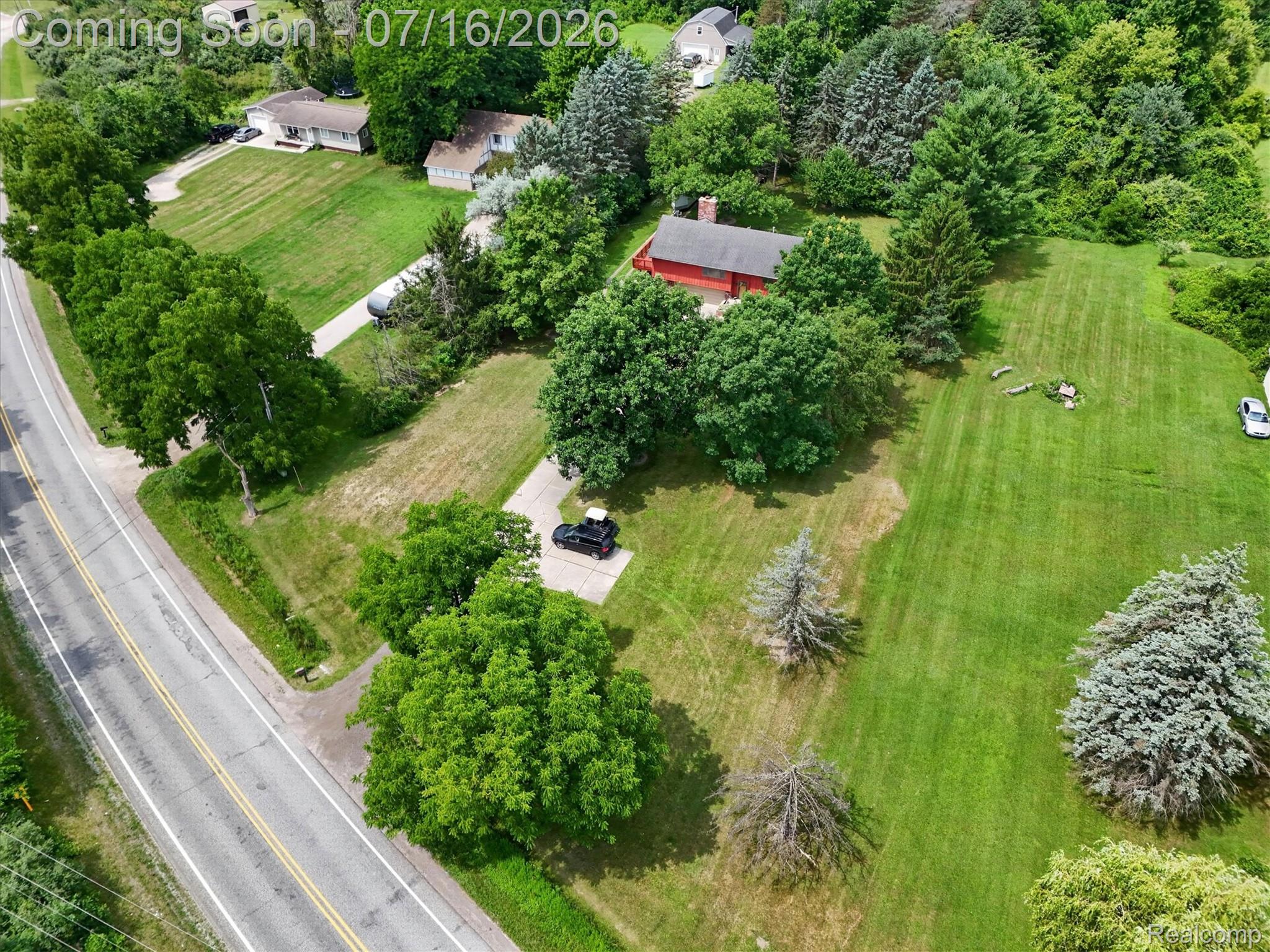 11210 Linden Road Linden, MI 48451 - Photo 51 of 61 Expansive property featuring a red-sided structure, surrounded by mature trees and lush green lawns