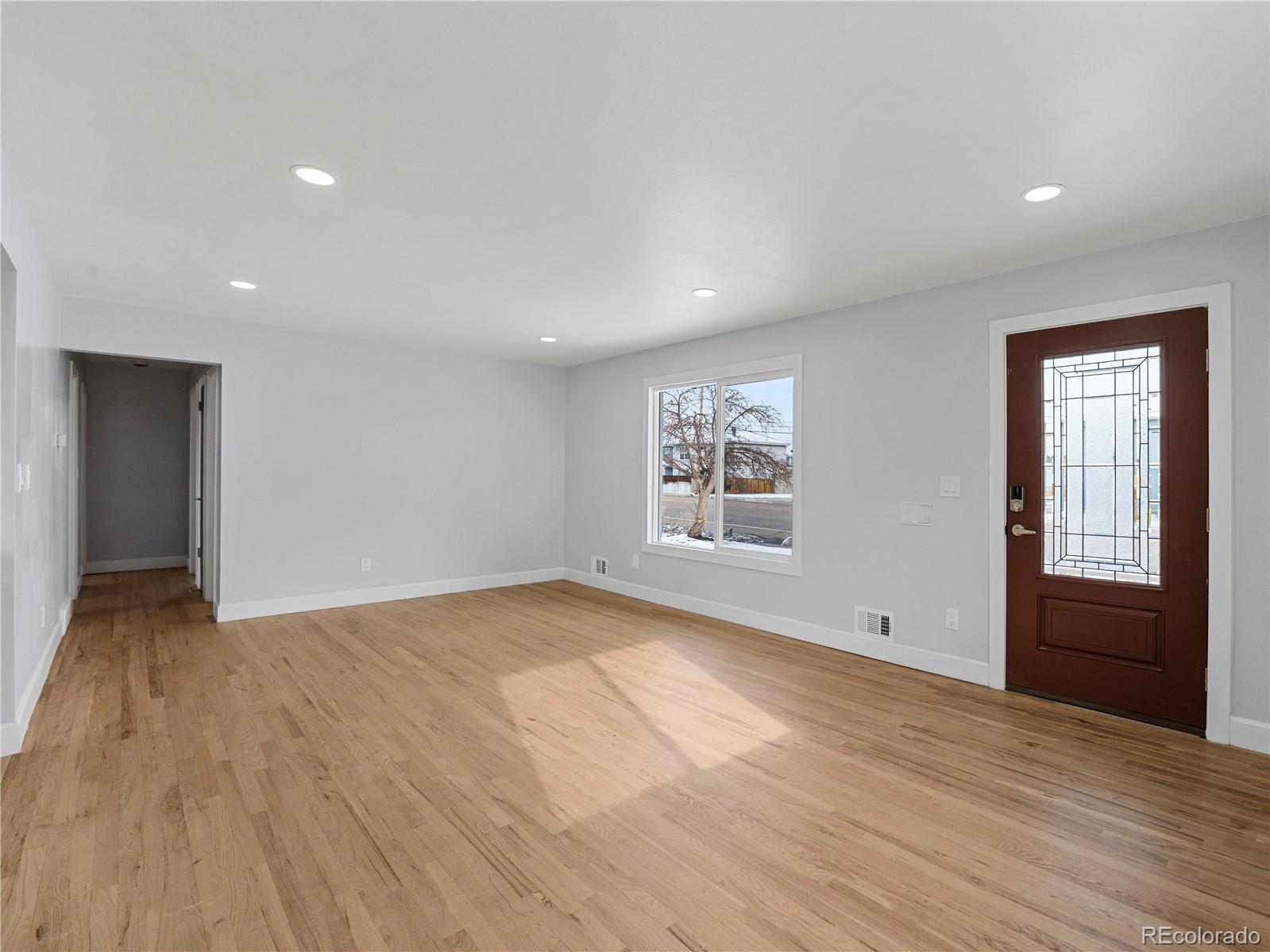 7889 North Pecos Street Denver, CO 80221 - Photo 14 of 42 a view of an empty room with a window and wooden floor