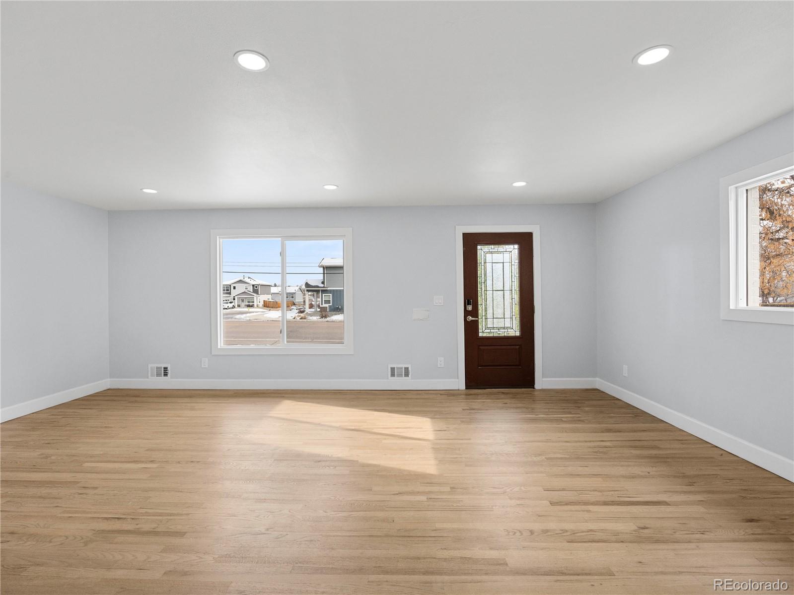 7889 North Pecos Street Denver, CO 80221 - Photo 17 of 42 an empty room with wooden floor and windows