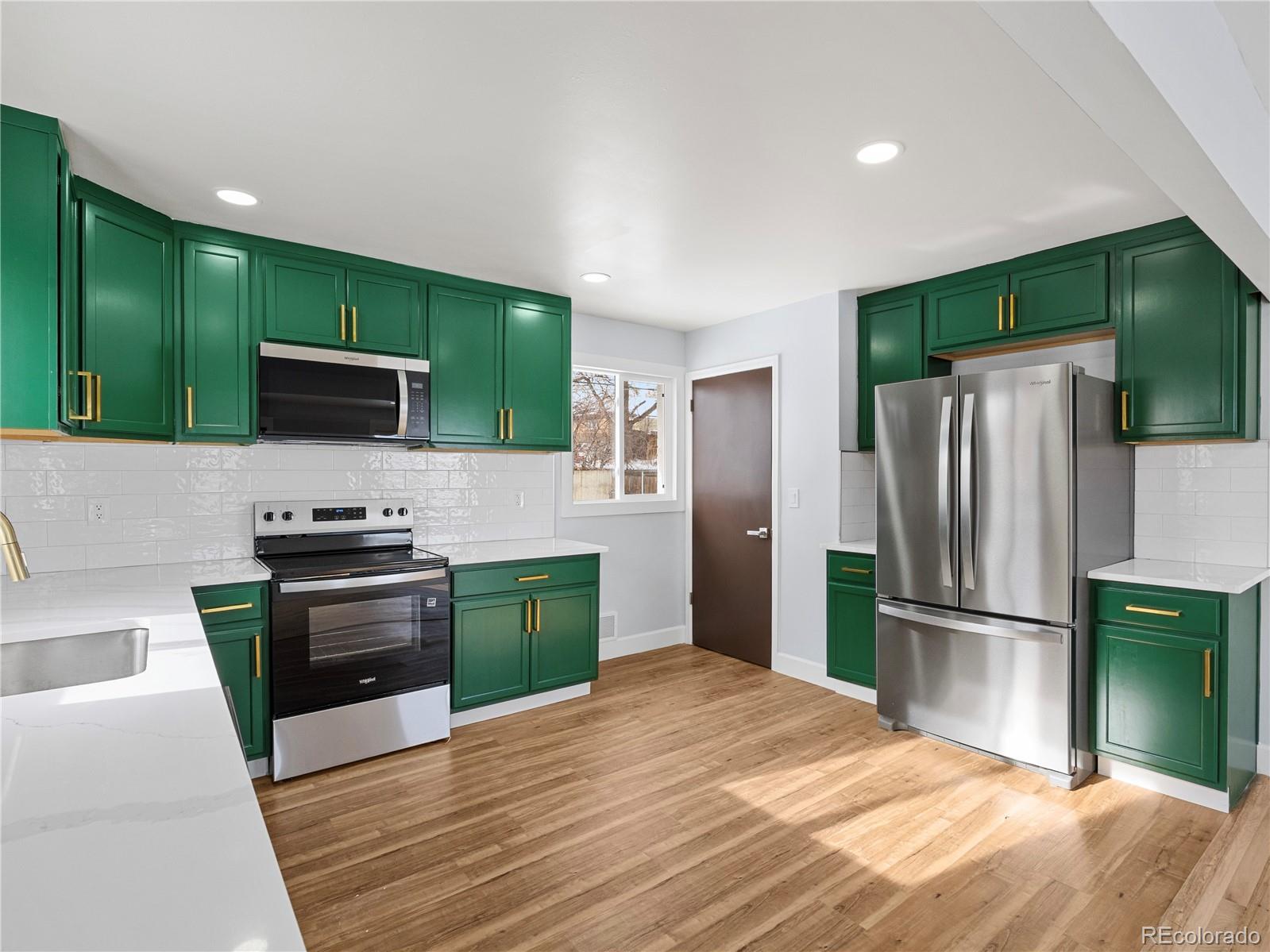 7889 North Pecos Street Denver, CO 80221 - Photo 20 of 42 a kitchen with granite countertop a refrigerator stove and microwave
