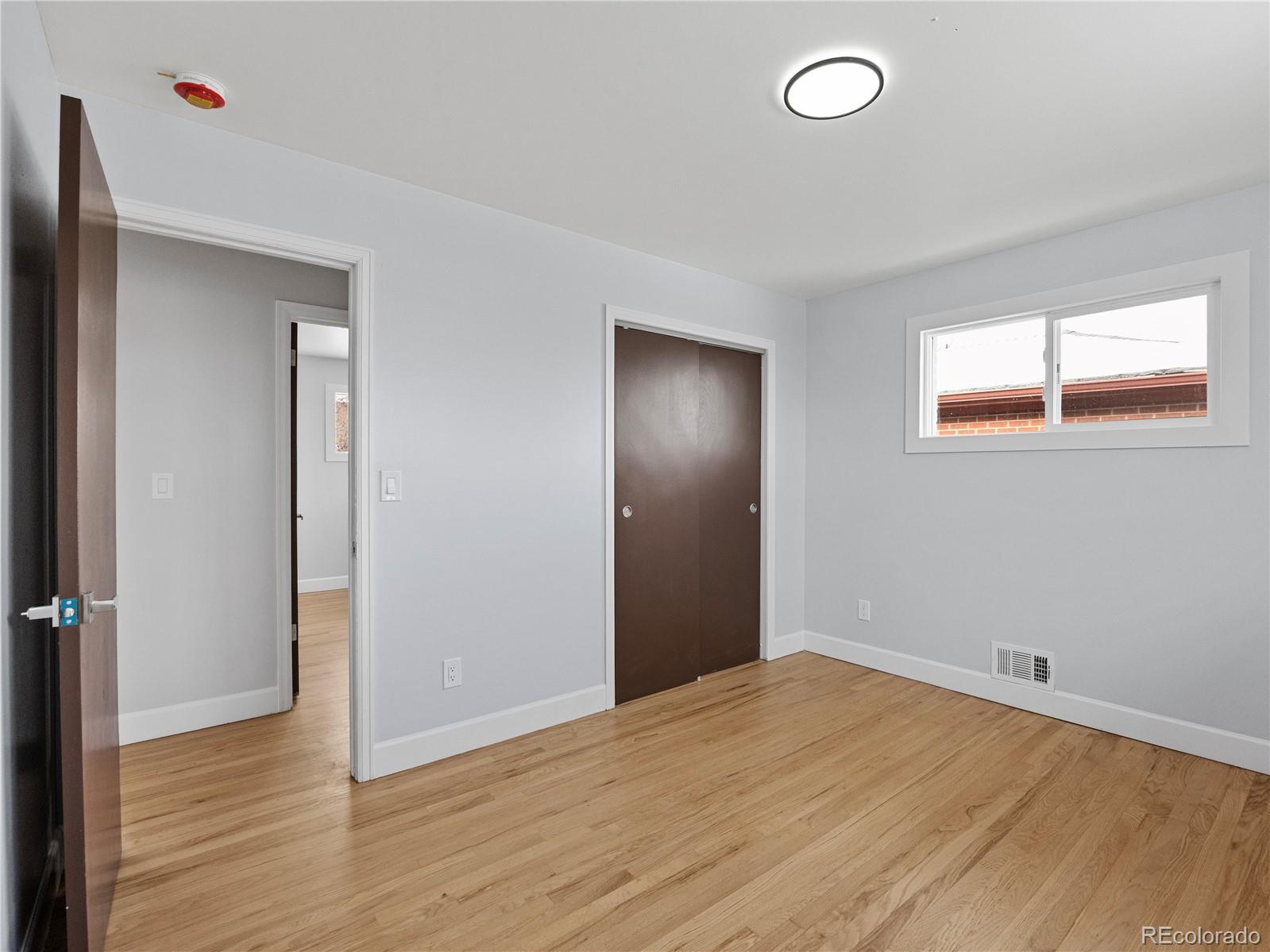 7889 North Pecos Street Denver, CO 80221 - Photo 24 of 42 an empty room with wooden floor and windows
