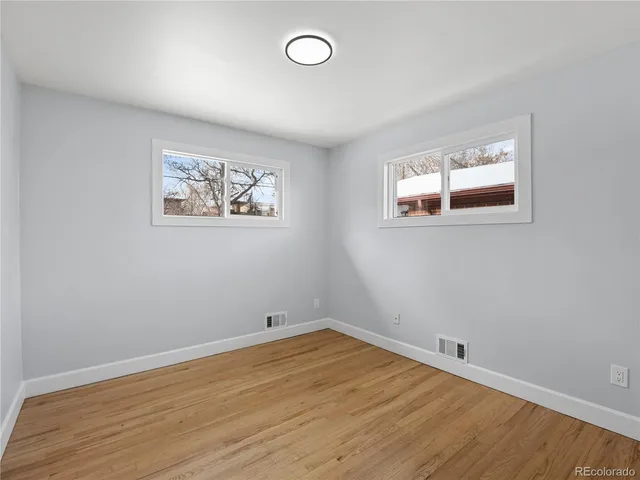 a view of empty room with wooden floor