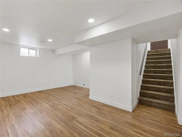 a view of an empty room with wooden floor and closet