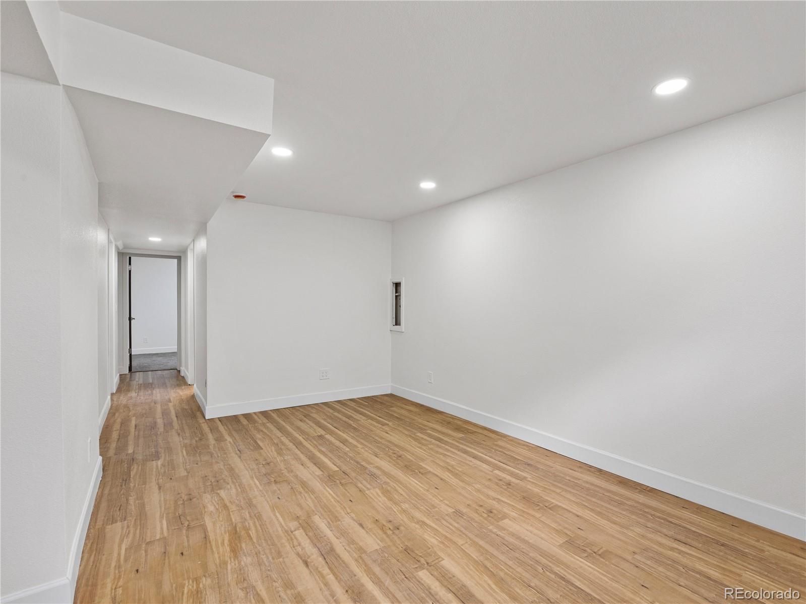 7889 North Pecos Street Denver, CO 80221 - Photo 32 of 42 an empty room with wooden floor and windows