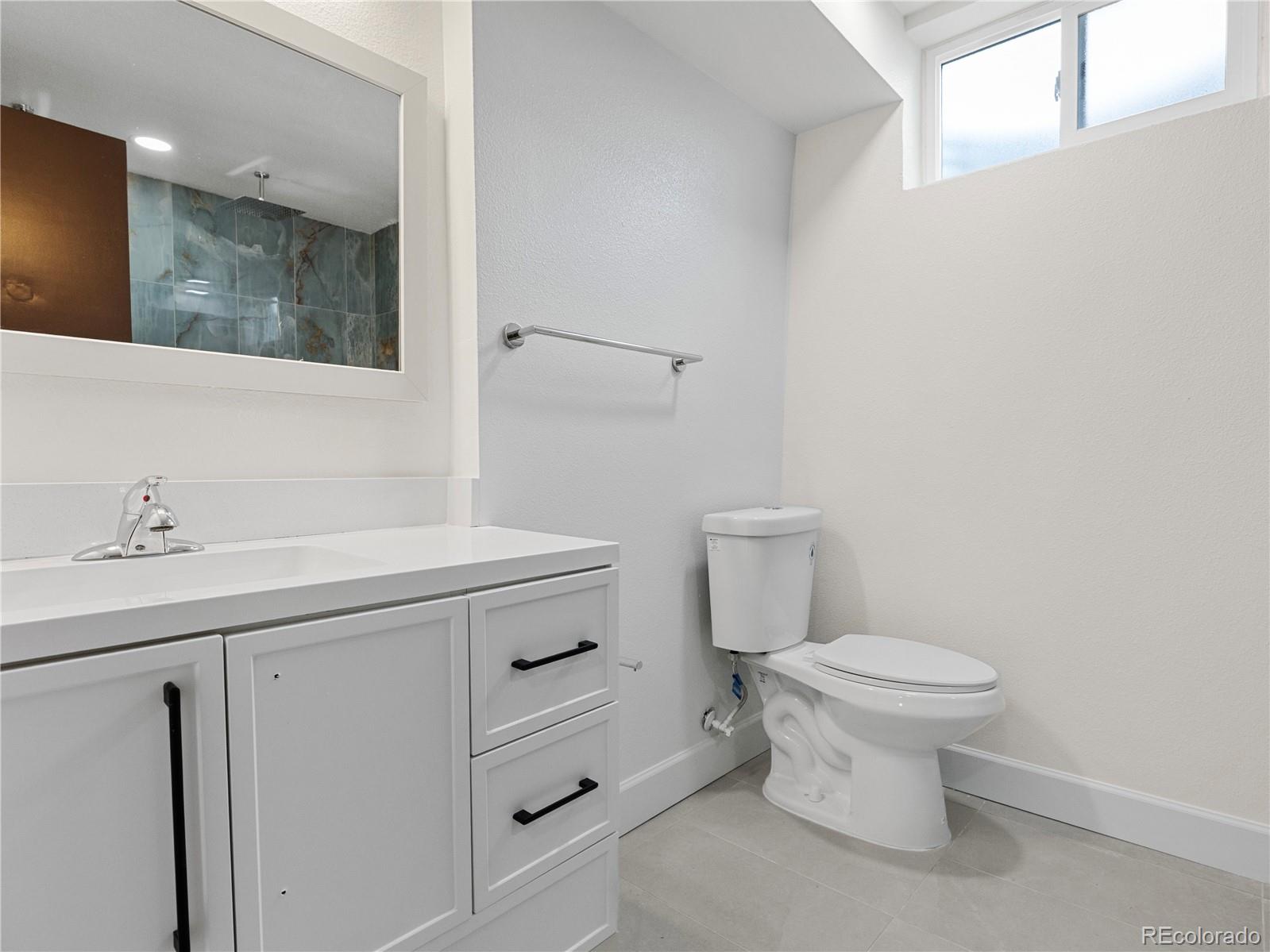 7889 North Pecos Street Denver, CO 80221 - Photo 38 of 42 a bathroom with a sink toilet and vanity