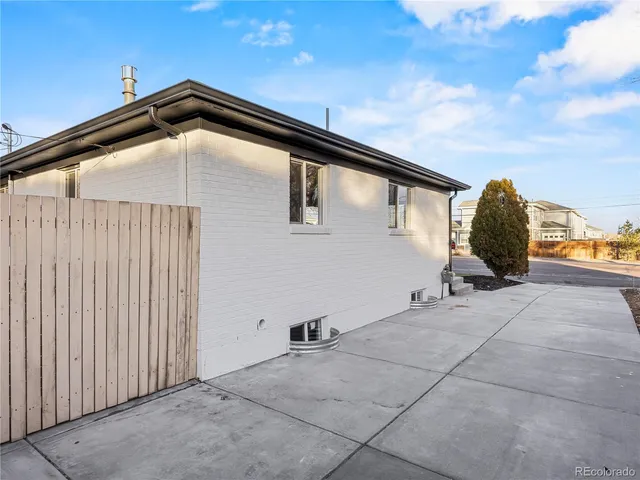a view of a house with backyard and wooden fence
