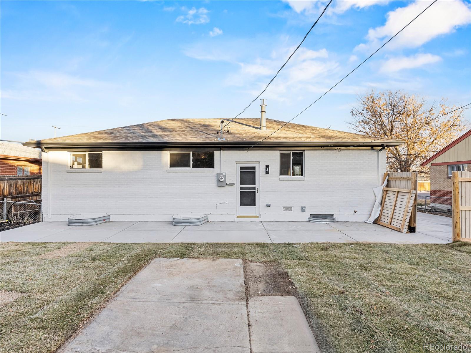 7889 North Pecos Street Denver, CO 80221 - Photo 9 of 42 a front view of a house with a yard
