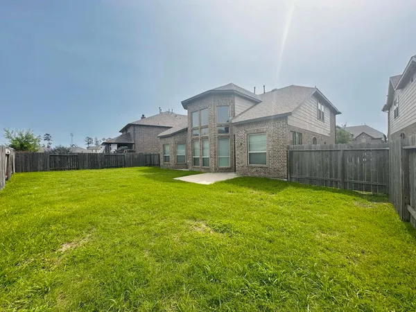 a view of a house with backyard and a tree