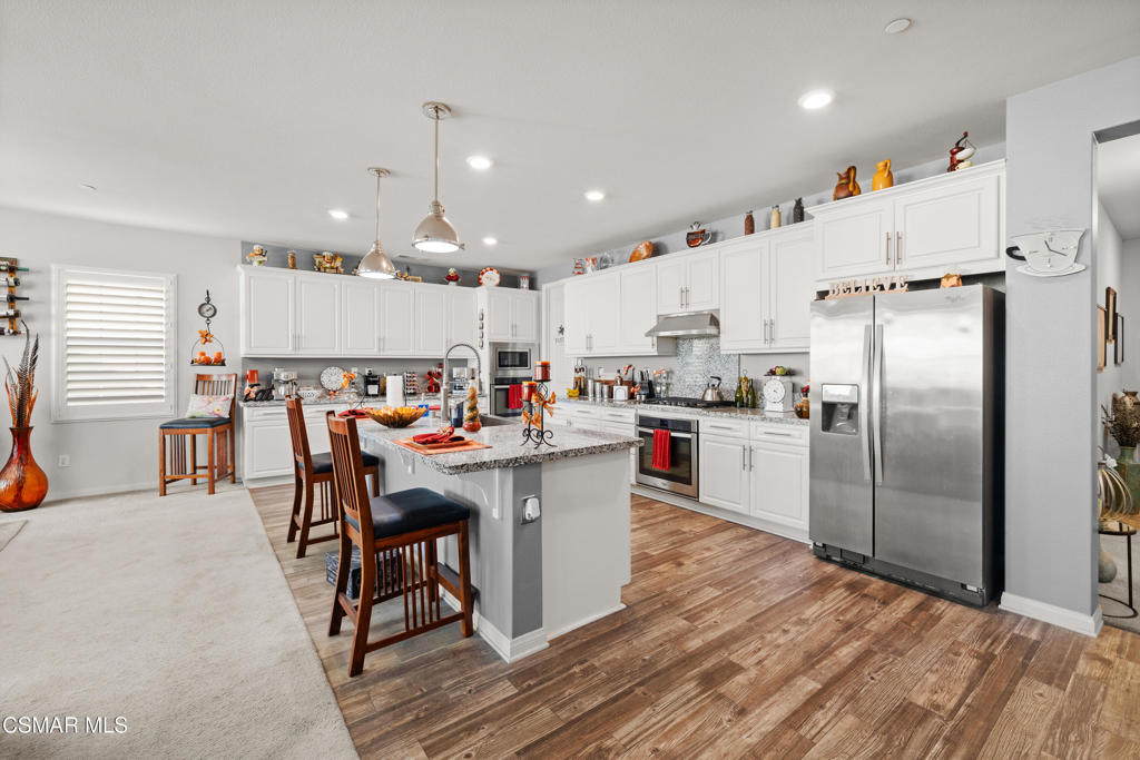 417 White Bark Lane Simi Valley, CA 93065 - Photo 11 of 30 a kitchen with kitchen island a white counter top space a sink appliances and cabinets