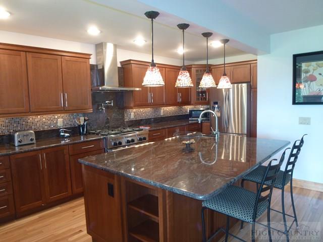 775 Miners Ridge Trail Banner Elk, NC 28604 - Photo 16 of 41 a kitchen with stainless steel appliances granite countertop a sink a stove and a wooden cabinets