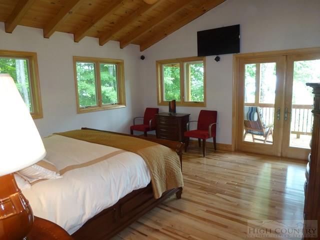 775 Miners Ridge Trail Banner Elk, NC 28604 - Photo 21 of 41 a spacious bedroom with a bed and wooden floor