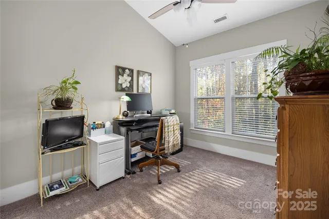 a view of a workspace with furniture and a window