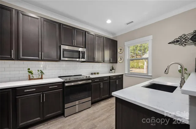 a kitchen with stainless steel appliances granite countertop a sink stove and microwave
