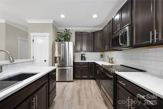 a kitchen with a sink stainless steel appliances and cabinets