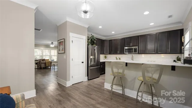 a kitchen with stainless steel appliances kitchen island granite countertop a refrigerator and a stove top oven