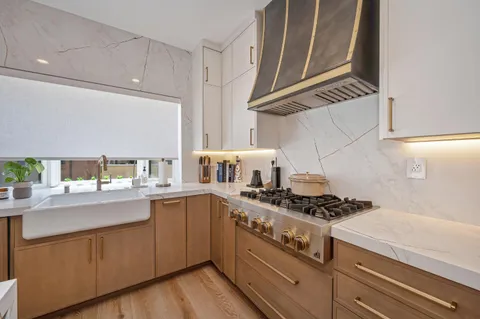 a kitchen with stainless steel appliances a stove a sink and a refrigerator