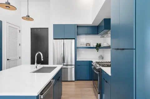 a kitchen with stainless steel appliances granite countertop a sink and a refrigerator