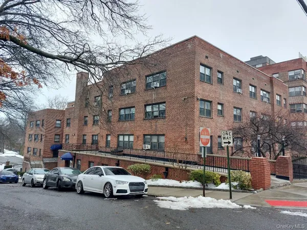 a couple of cars parked in front of brick building
