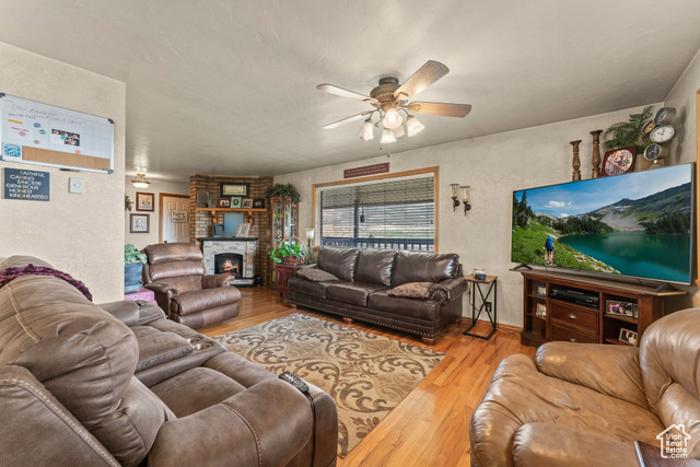 6407 North Dry Frk Cyn Road West Vernal, UT 84078 - Photo 20 of 48 Living room with a ceiling fan, wood finished floors, and a fireplace