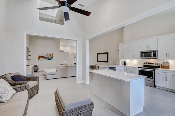a living room with stainless steel appliances furniture and a chandelier
