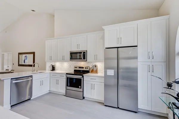 a kitchen with white cabinets and stainless steel appliances