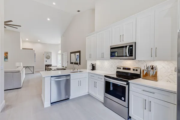 a kitchen with cabinets stainless steel appliances a sink and a stove