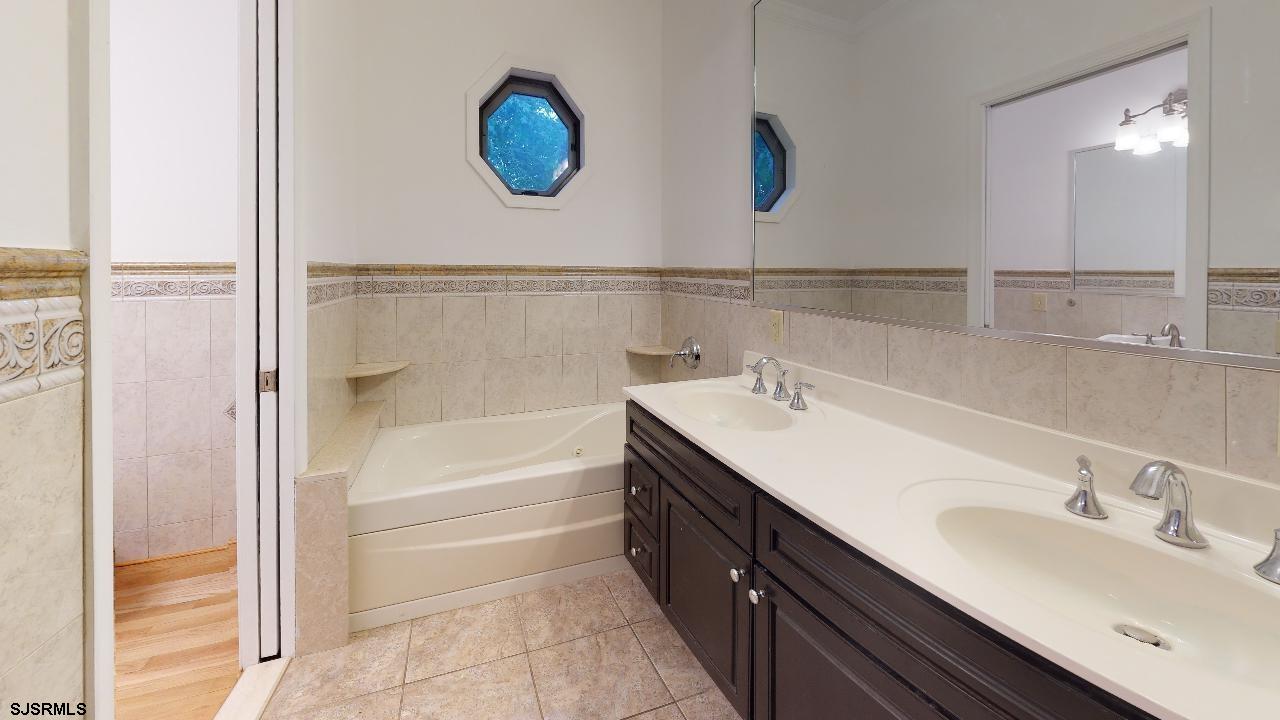 9 Edward Terrace Ocean View, NJ 08230 - Photo 28 of 30 a bathroom with a double vanity sink a mirror and a shower