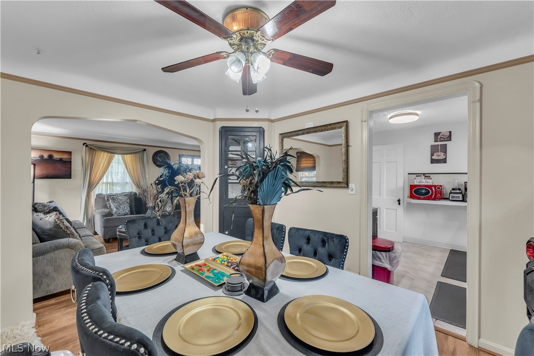 3962 Grosvenor Road South Euclid, OH 44118 - Photo 9 of 27 Dining area featuring a ceiling fan with integrated lighting, wood-finish flooring, and arched entryway