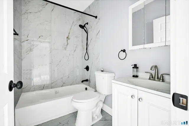 a view of a livingroom with a fireplace a ceiling fan and wooden floor