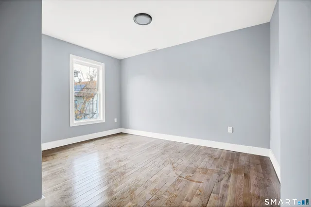 wooden floor in an empty room with a window