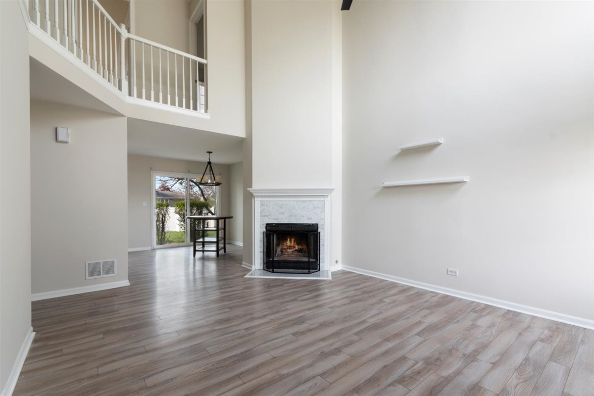 1171 Longford Road Bartlett, IL 60103 - Photo 2 of 22 a view of an empty room with wooden floor and a fireplace