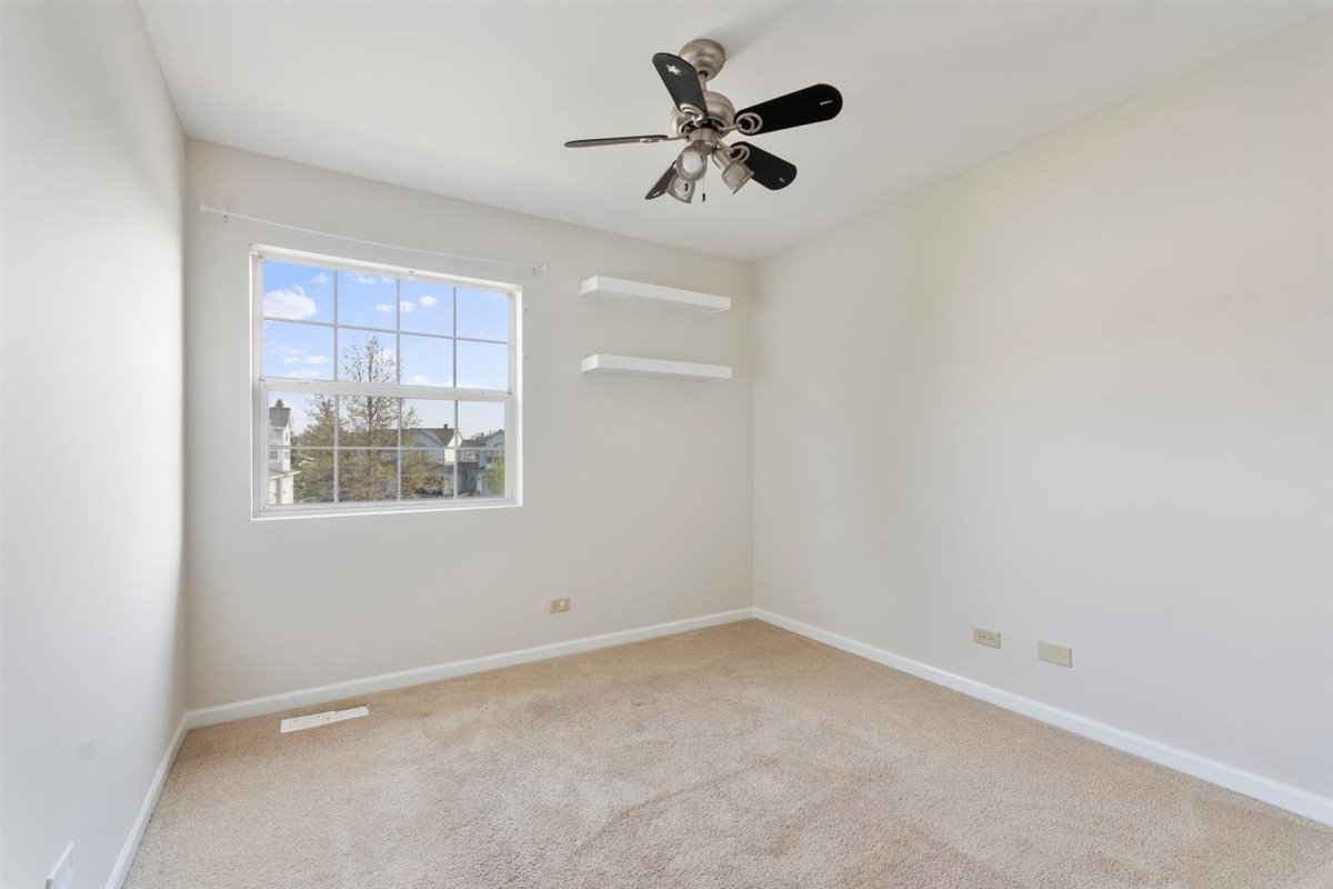 1171 Longford Road Bartlett, IL 60103 - Photo 12 of 22 an empty room with a window and a fan