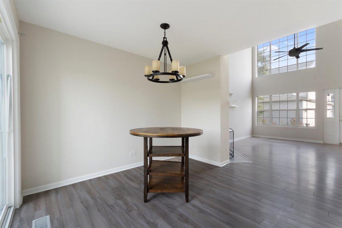 1171 Longford Road Bartlett, IL 60103 - Photo 5 of 22 a view of a room with wooden floor a chandelier and windows