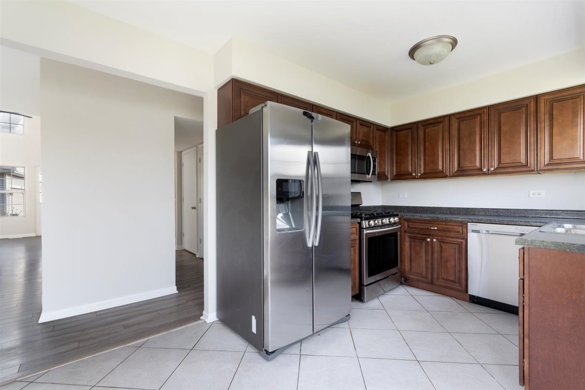 1171 Longford Road Bartlett, IL 60103 - Photo 6 of 22 a kitchen with stainless steel appliances granite countertop a refrigerator and a stove top oven