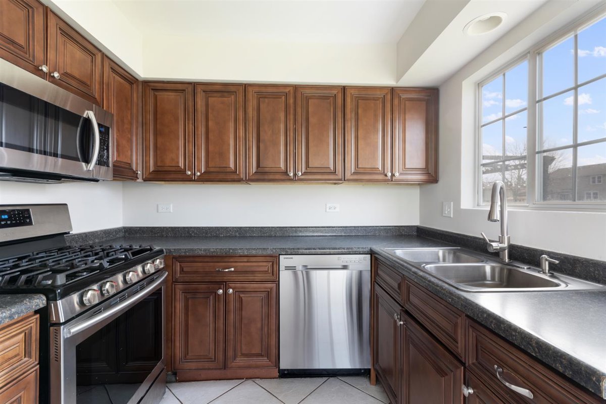 1171 Longford Road Bartlett, IL 60103 - Photo 9 of 22 a kitchen with granite countertop a sink stove and cabinets