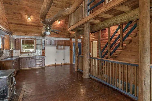 a view of a hallway with wooden floor and a kitchen