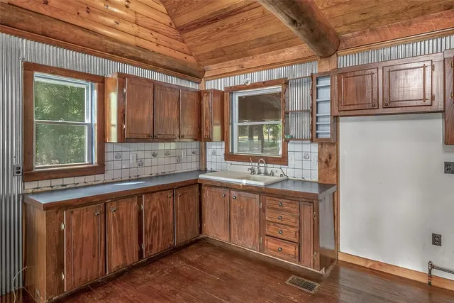 a kitchen with stainless steel appliances granite countertop a sink and cabinets with wooden floor