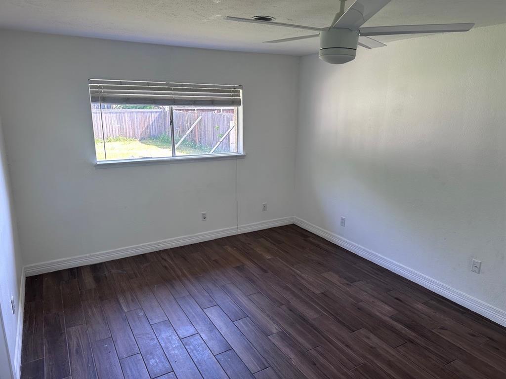 2103 Carlton Road Carrollton, TX 75007 - Photo 4 of 18 a view of an empty room with wooden floor and a window