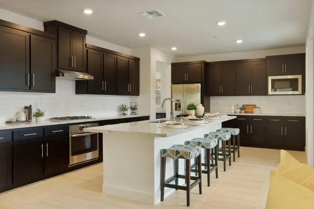 a kitchen with stainless steel appliances kitchen island granite countertop a sink and cabinets