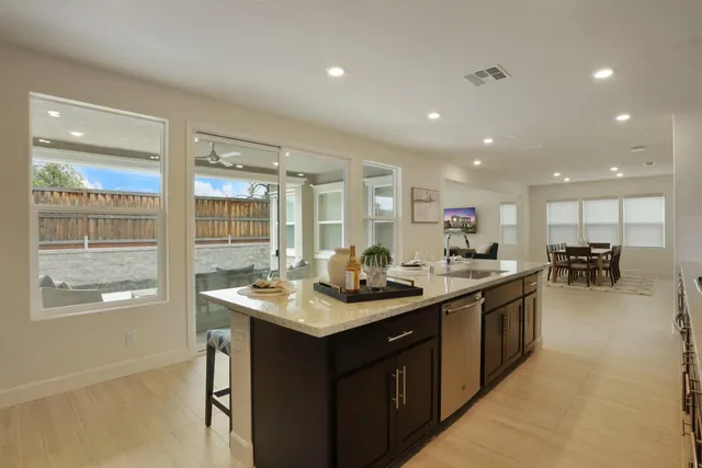 a kitchen with kitchen island a sink and a stove top oven