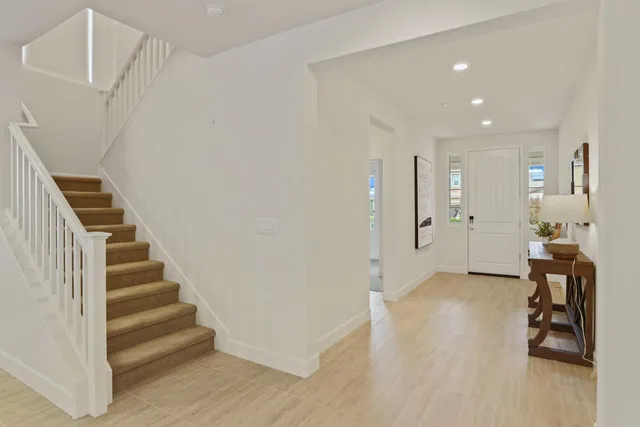 a view of a livingroom with wooden floor and stairs
