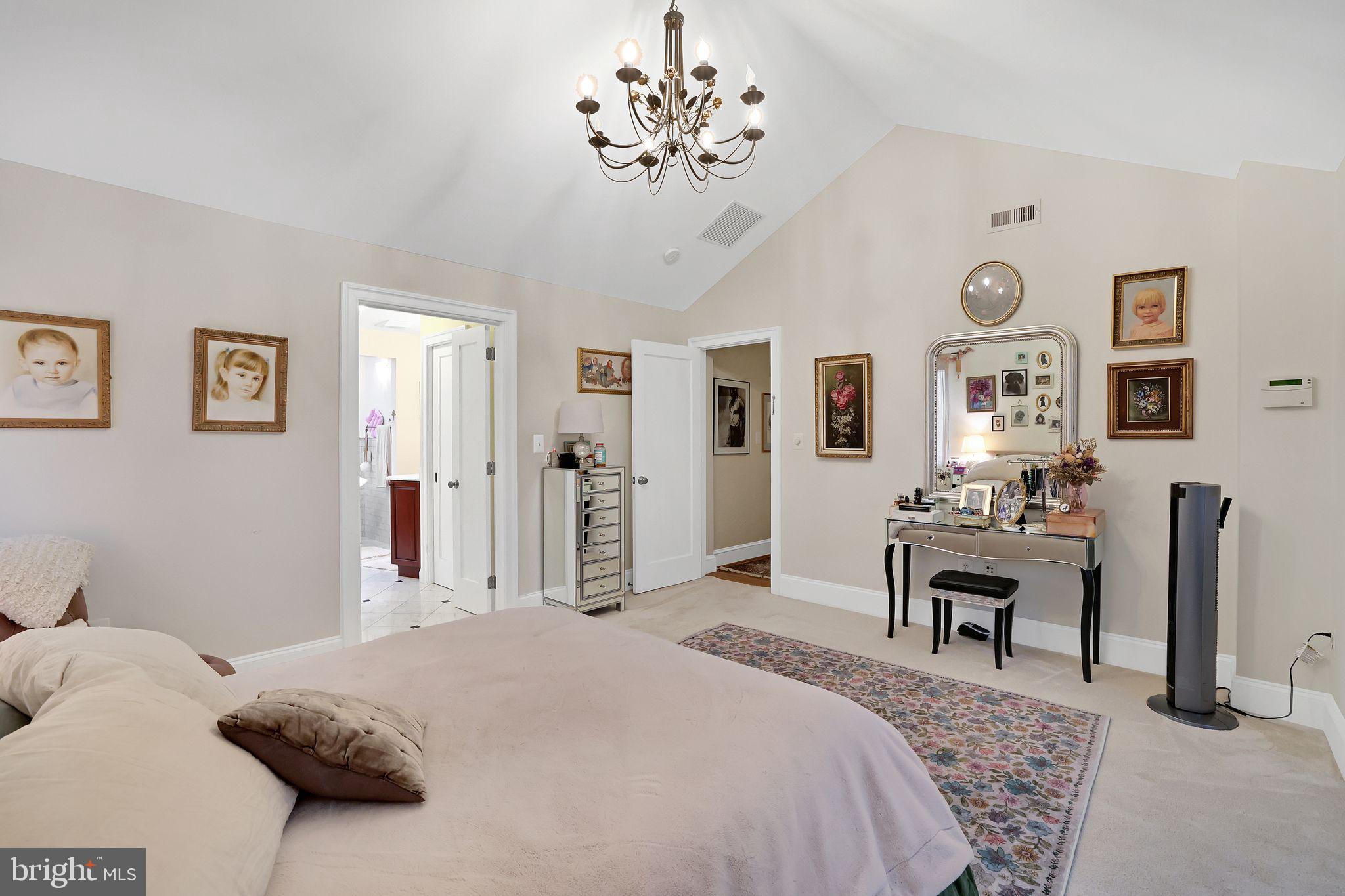 8510 Woodhaven Boulevard Bethesda, MD 20817 - Photo 11 of 18 a bedroom with a bed and a chandelier