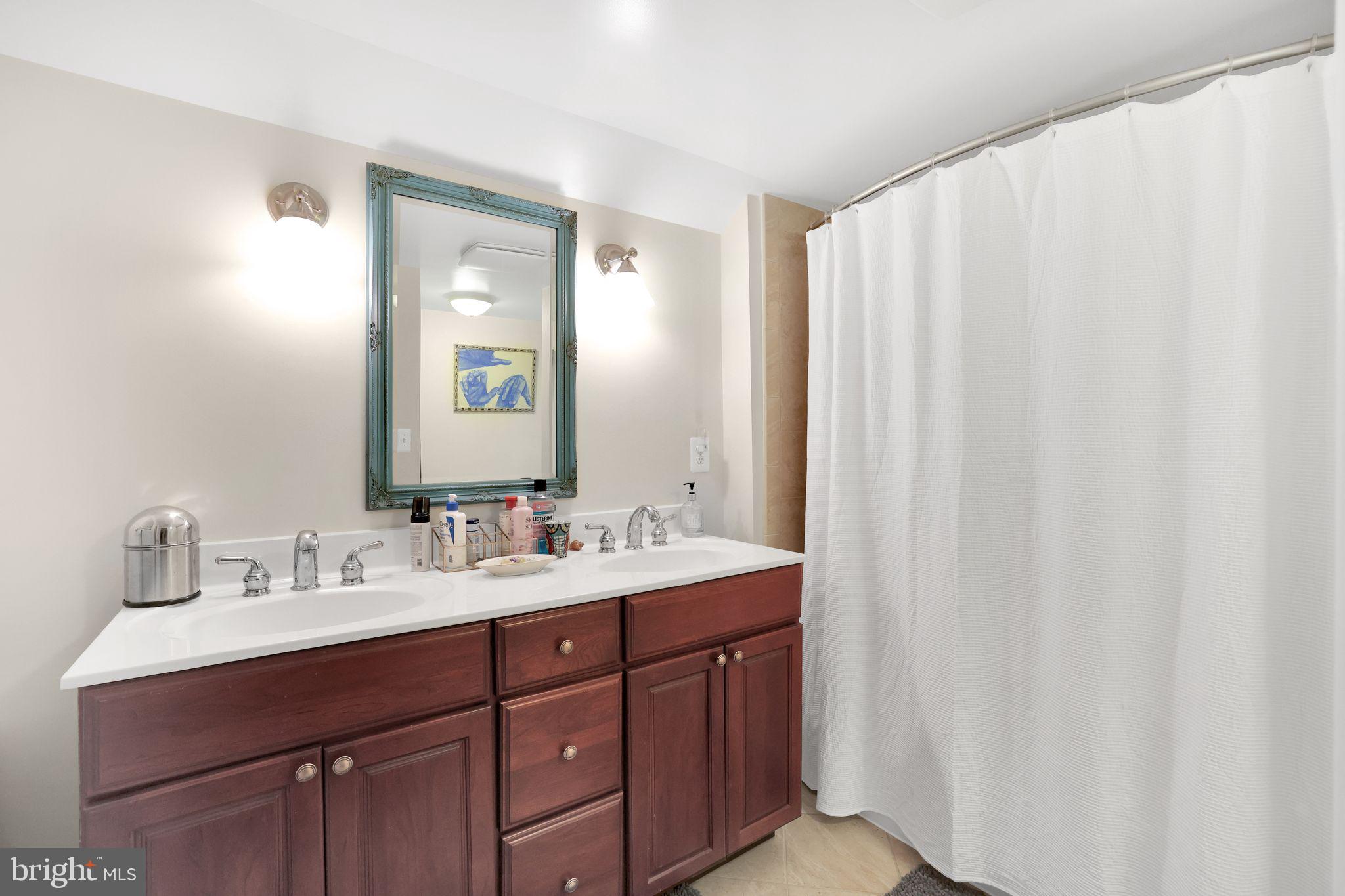 8510 Woodhaven Boulevard Bethesda, MD 20817 - Photo 15 of 18 a bathroom with a double vanity sink and a mirror