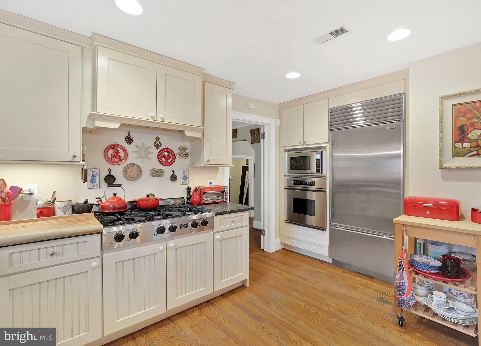 8510 Woodhaven Boulevard Bethesda, MD 20817 - Photo 6 of 18 a kitchen that has cabinets stove and wooden floor